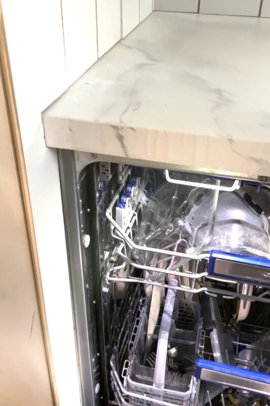 Smeg dishwasher with a DIY shiplap backsplash.
